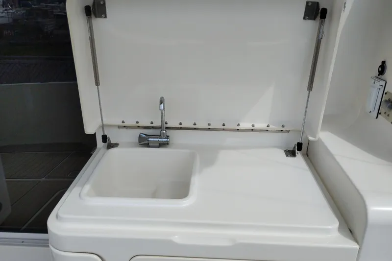 Slide: The Image of 2005 Silverton 38 Convertible yacht sink with chrome faucet and white countertop. - 14