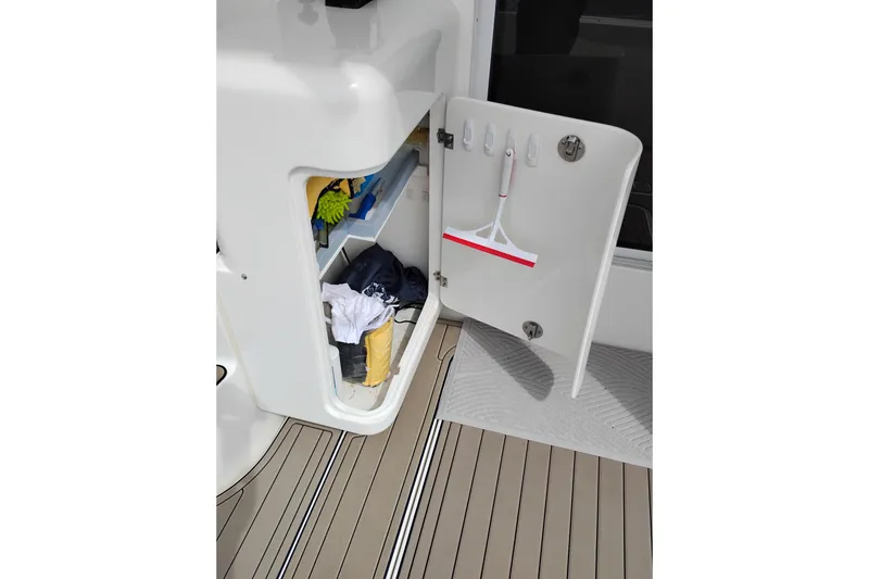 Slide: The Image of Open storage compartment on 2005 Silverton 38 Convertible boat with cleaning supplies. - 19