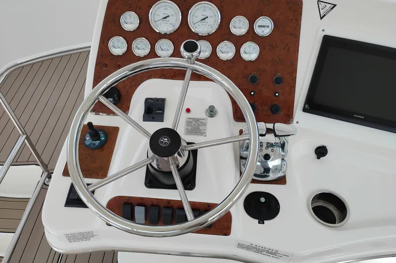 Slide: The Image of 2005 Silverton 38 Convertible helm with steering wheel, gauges, and navigation equipment. - 24