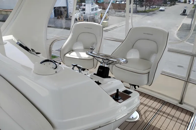Slide: The Image of 2005 Silverton 38 Convertible yacht helm with dual captain chairs and steering wheel. - 34