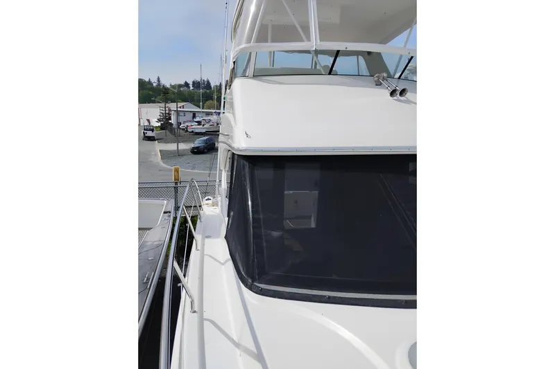Slide: The Image of 2005 Silverton 38 Convertible yacht docked at a marina, showcasing sleek design. - 44
