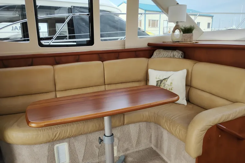 Slide: The Image of Luxurious interior of 2005 Silverton 38 Convertible yacht with beige seating and wooden table. - 55