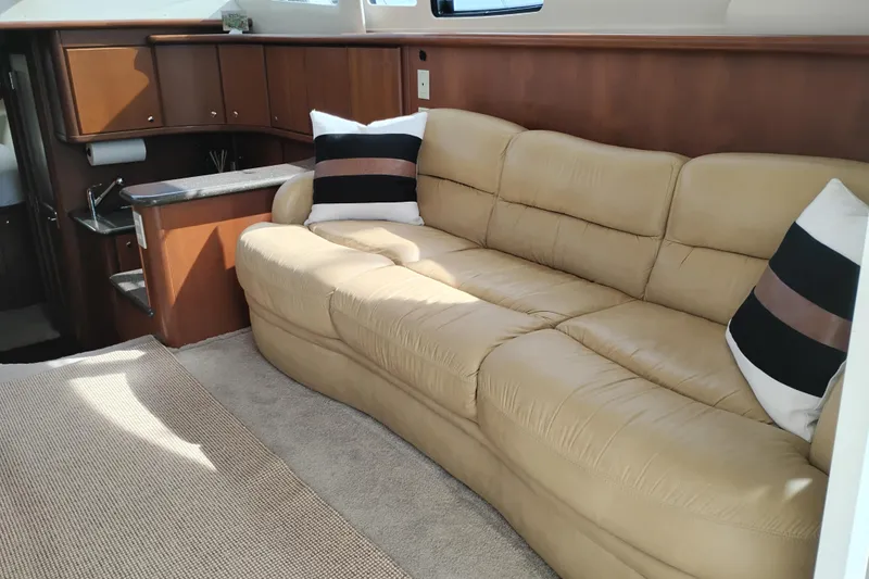 Slide: The Image of Interior of 2005 Silverton 38 Convertible yacht with beige leather sofa and striped pillows. - 56