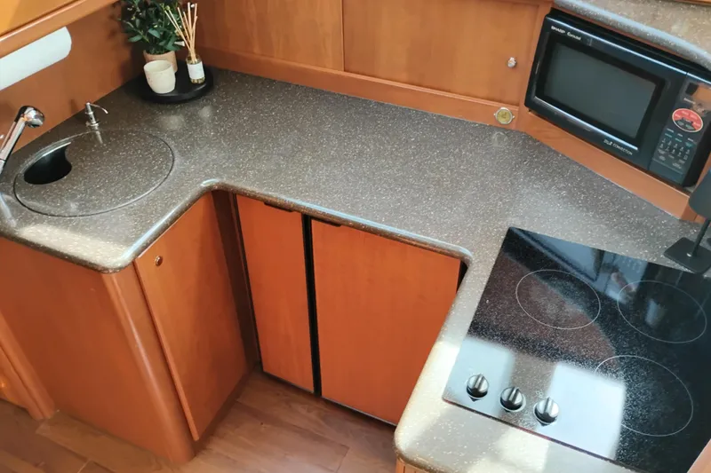 Slide: The Image of 2005 Silverton 38 Convertible yacht kitchen with sink, stove, and microwave. - 60