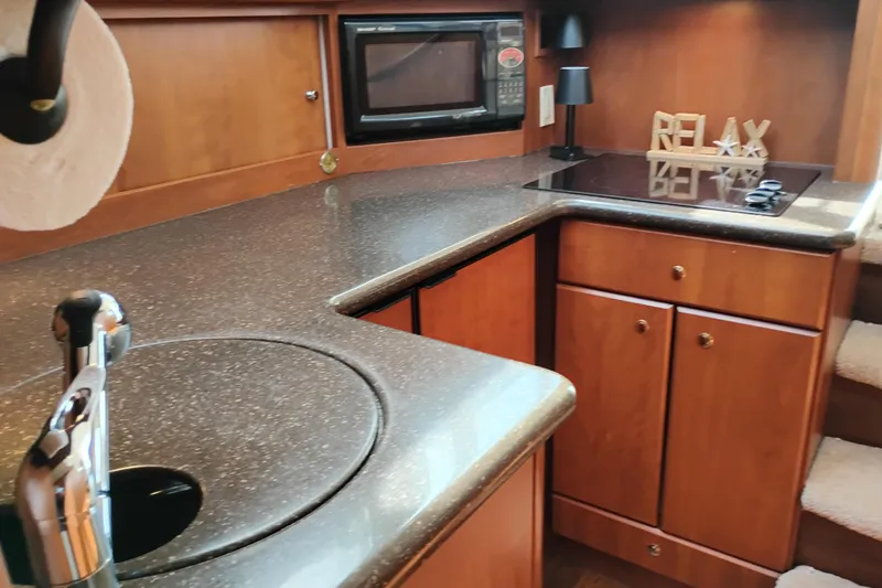 Slide: The Image of 2005 Silverton 38 Convertible yacht kitchen with modern appliances and wooden cabinetry. - 62