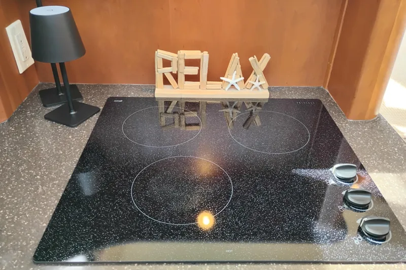 Slide: The Image of Modern kitchen cooktop on 2005 Silverton 38 Convertible yacht, with "RELAX" decor and lamp. - 65