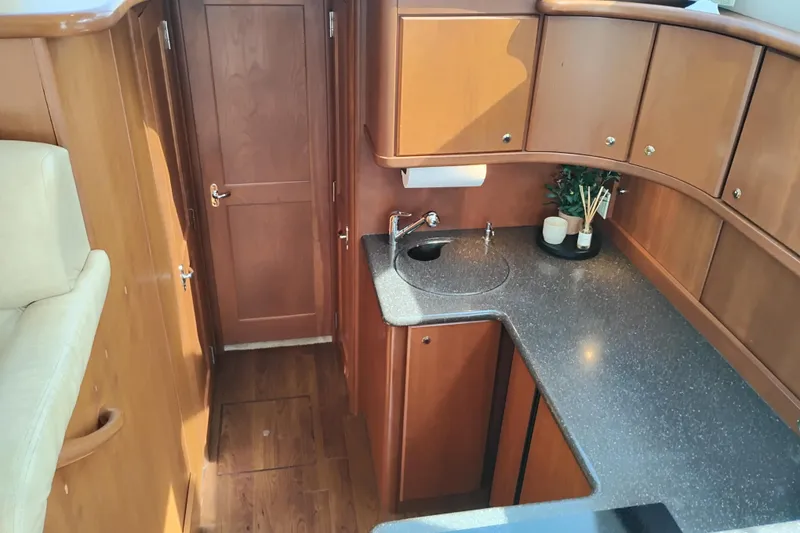 Slide: The Image of 2005 Silverton 38 Convertible yacht interior with wooden cabinetry and sleek countertop. - 67
