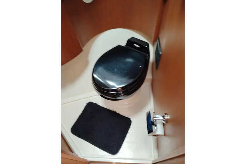 Slide: The Image of 2005 Silverton 38 Convertible yacht bathroom with black toilet seat and mat. - 75