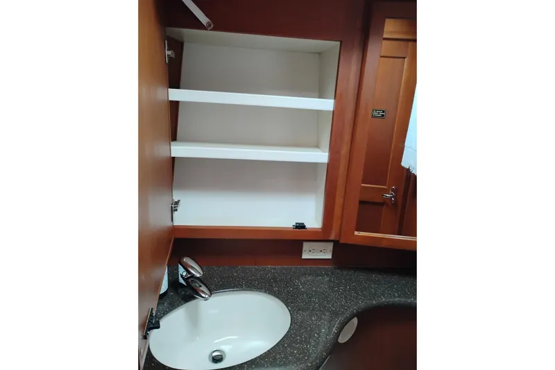 Slide: The Image of 2005 Silverton 38 Convertible yacht bathroom with sink, shelves, and wooden cabinetry. - 76