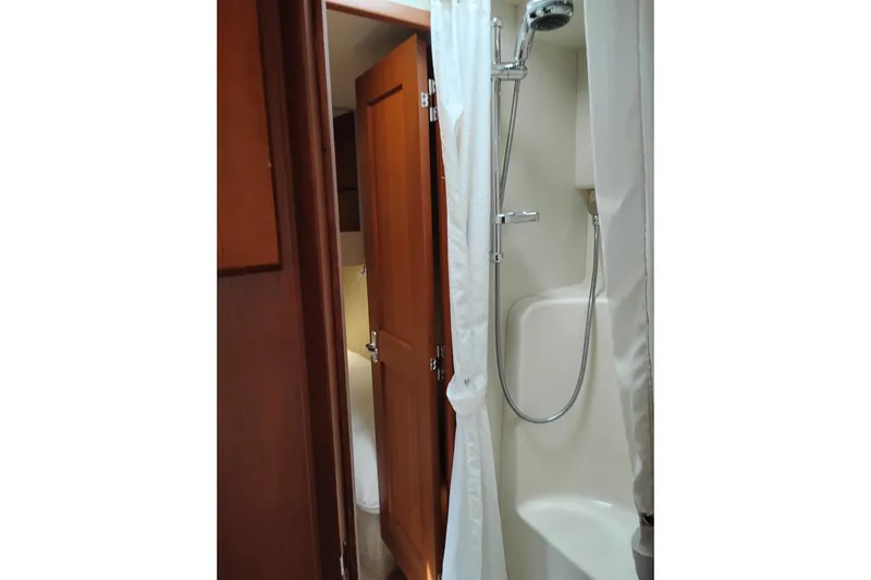 Slide: The Image of 2005 Silverton 38 Convertible yacht bathroom with shower and wooden door. - 77