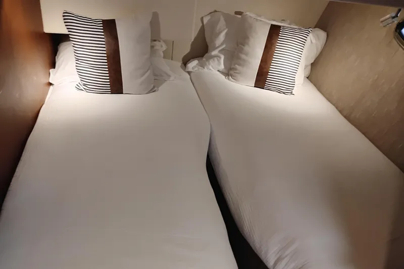 Slide: The Image of Twin beds with striped pillows in a 2005 Silverton 38 Convertible yacht cabin. - 80