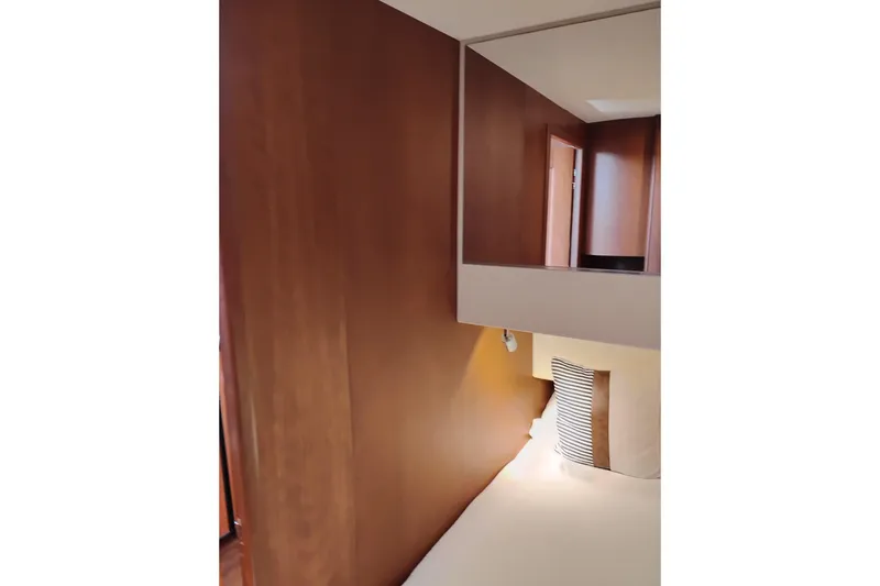 Slide: The Image of Interior of 2005 Silverton 38 Convertible yacht with wooden paneling and cozy bedding. - 81
