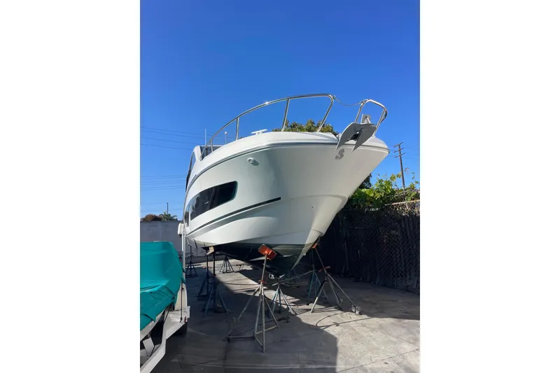 Slide: The Image of 2023 Beneteau Gran Turismo 32 yacht on stands under clear blue sky. - 3