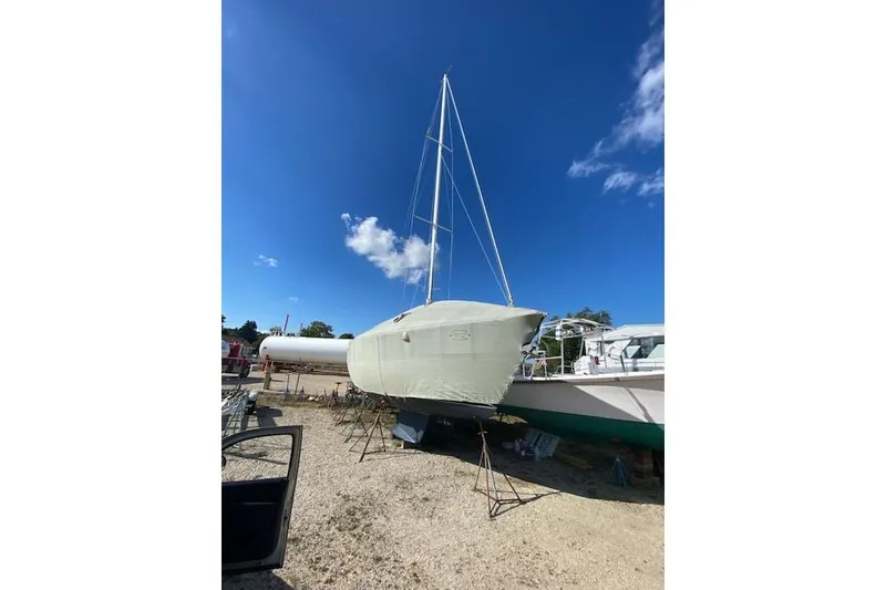 Slide: The Image of 1992 Tartan 31 Piper sailboat covered and docked under a clear blue sky. - 13
