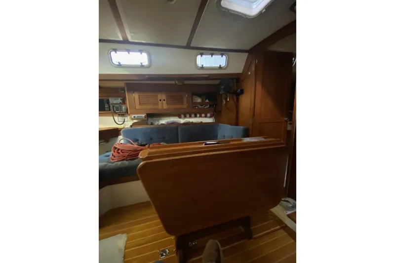 Slide: The Image of Interior of a 1992 Tartan 31 Piper sailboat with wooden furnishings and blue seating. - 6