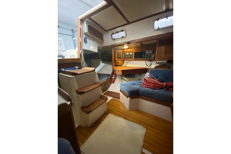 Slide: The Image of Interior of 1992 Tartan 31 Piper sailboat with wooden accents and cozy seating area. - 7