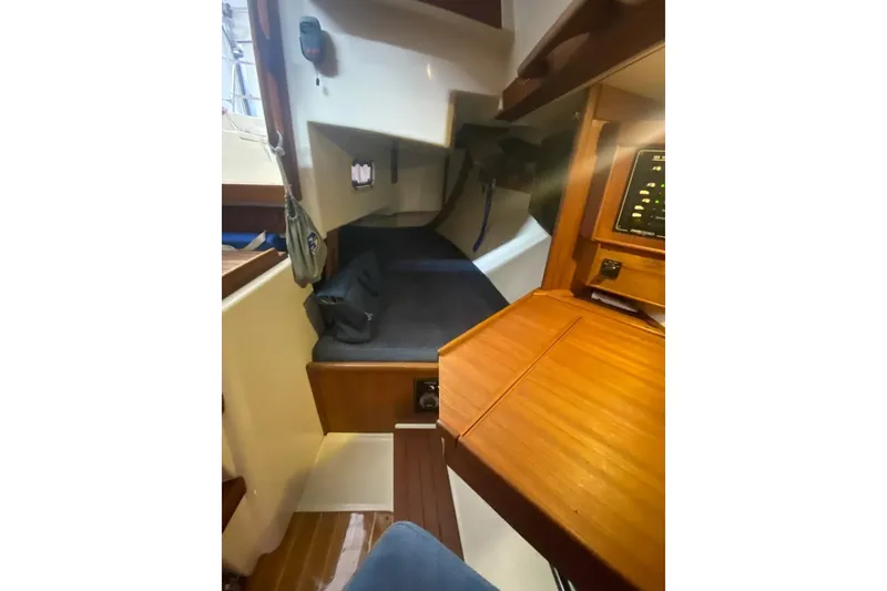 Slide: The Image of Interior of 1992 Tartan 31 Piper sailboat with wooden finishes and cozy sleeping area. - 8