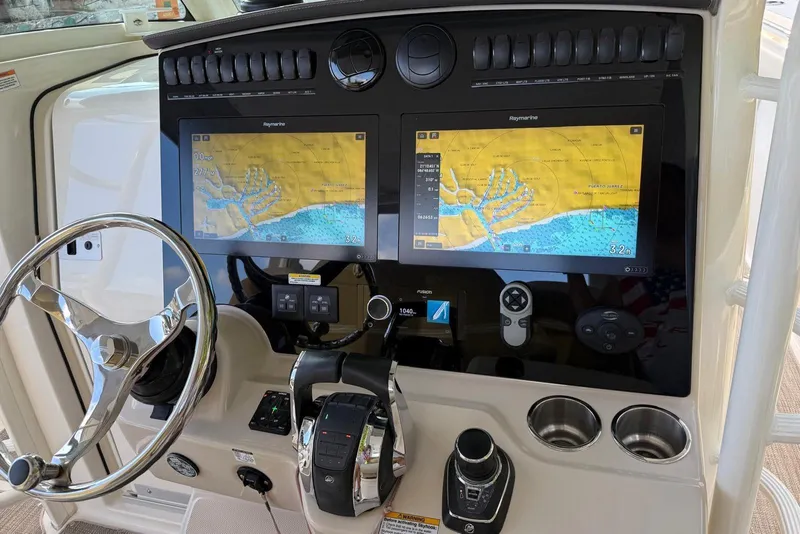 Slide: The Image of Helm of 2021 Boston Whaler 380 Outrage with dual navigation screens and controls. - 10