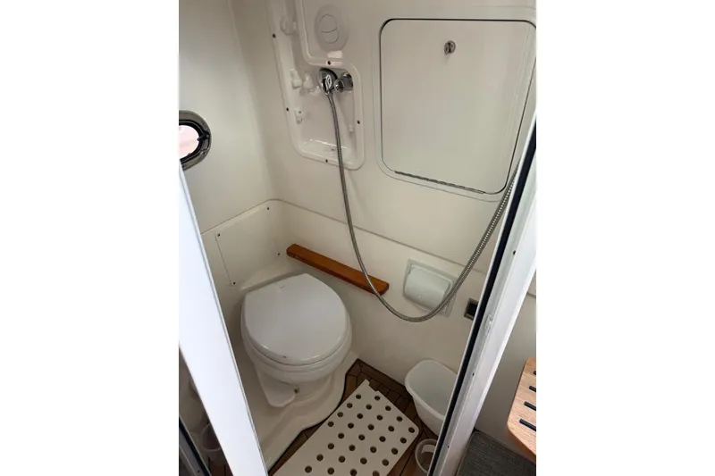 Slide: The Image of Compact bathroom in 2021 Boston Whaler 380 Outrage boat, featuring toilet and shower amenities. - 16