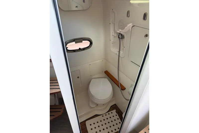 Slide: The Image of 2021 Boston Whaler 380 Outrage boat bathroom with toilet and showerhead. - 17