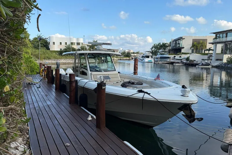 Slide: The Image of 2021 Boston Whaler 380 Outrage docked in a scenic marina setting. - 3