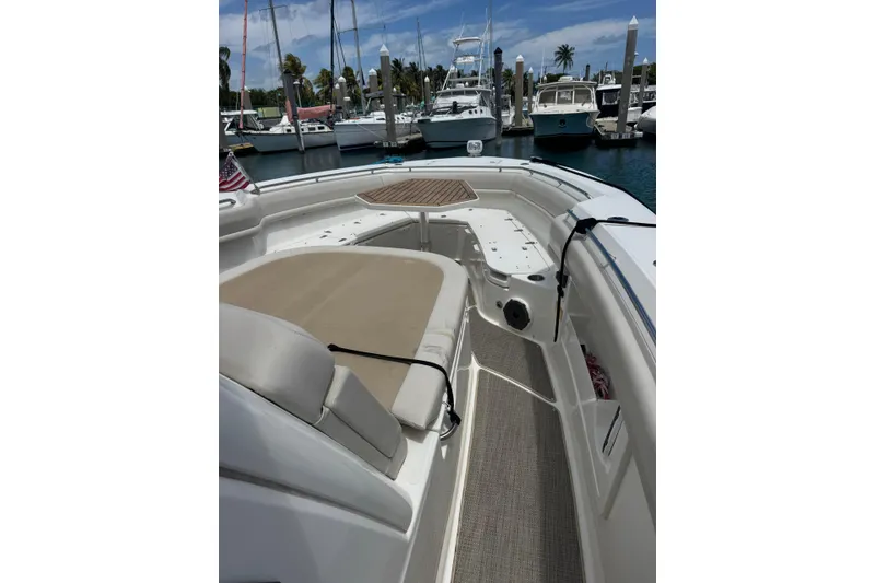 Slide: The Image of 2021 Boston Whaler 380 Outrage boat interior at marina, featuring seating and table. - 8