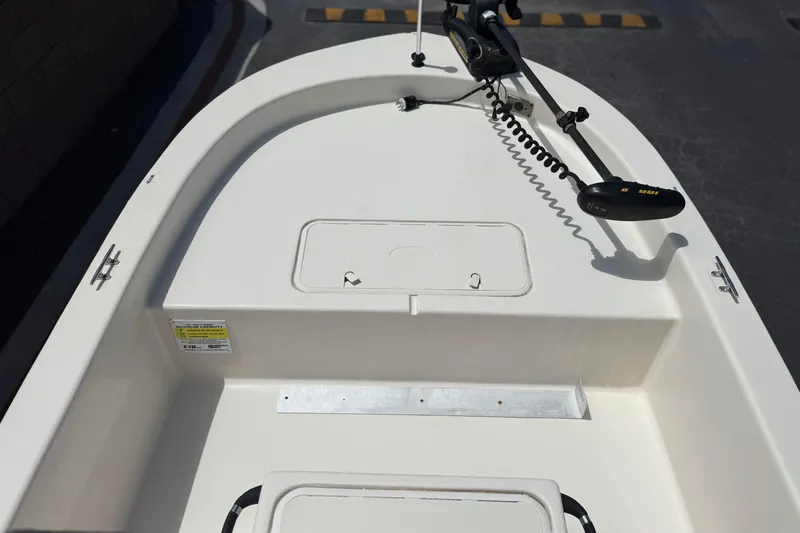 Slide: The Image of 2024 Carolina Skiff E18 JVX CC boat deck with trolling motor and storage hatch. - 11