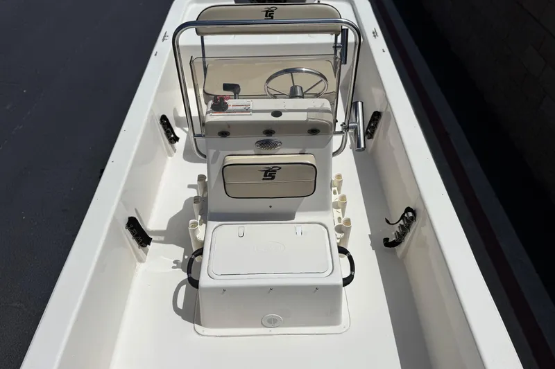 Slide: The Image of 2024 Carolina Skiff E18 JVX CC center console interior with steering wheel and storage compartments. - 13