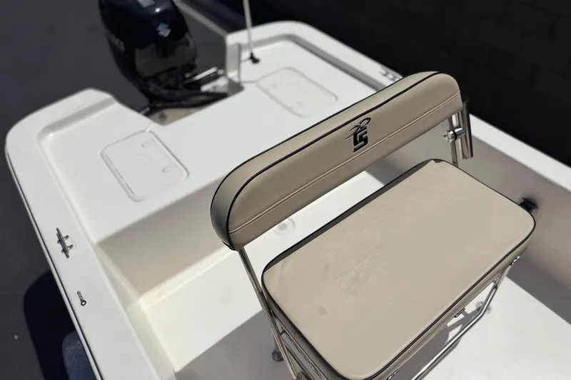 Slide: The Image of 2024 Carolina Skiff E18 JVX CC boat interior with cushioned seating and motor. - 17