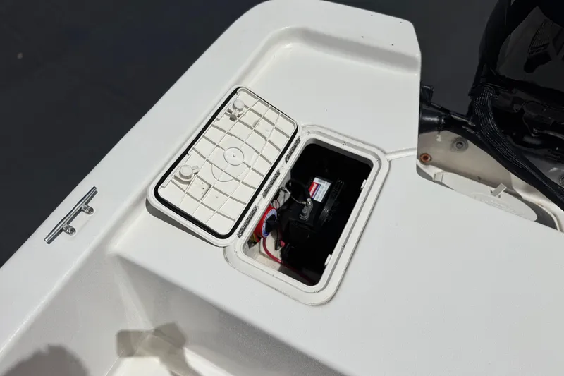 Slide: The Image of 2024 Carolina Skiff E18 JVX CC boat battery compartment with open hatch. - 19