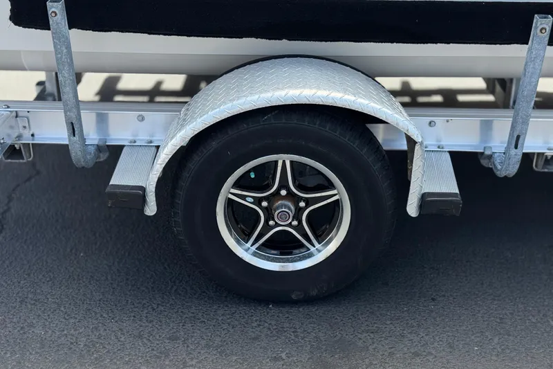 Slide: The Image of Trailer wheel of 2024 Carolina Skiff E18 JVX CC boat on pavement. - 23