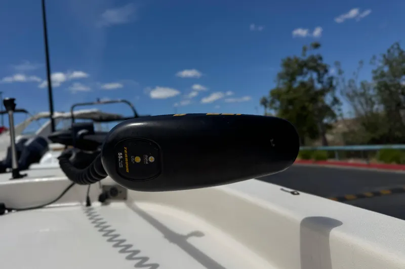 Slide: The Image of Close-up of a 2024 Carolina Skiff E18 JVX CC boat's trolling motor under a clear blue sky. - 9