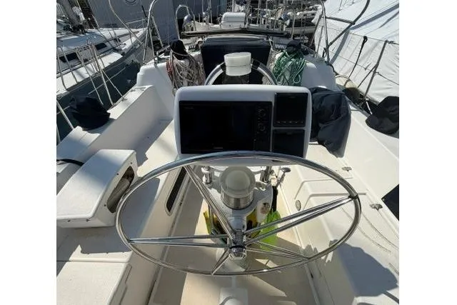 Slide: The Image of Steering wheel and cockpit of 2002 Saga 43 sailboat, featuring navigation equipment. - 13