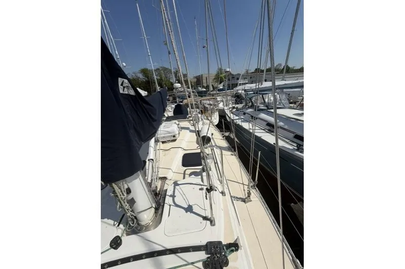 Slide: The Image of Sailboat deck view of 2002 Saga 43, docked with other boats under clear sky. - 18