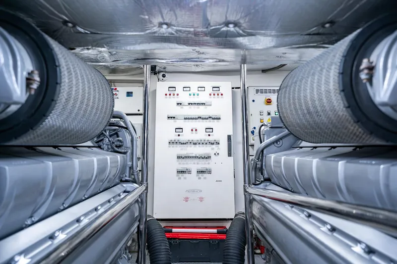 Slide: The Image of Engine room of a 2010 Pershing 80 yacht, featuring advanced control panels and machinery. - 100