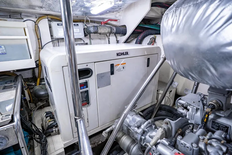 Slide: The Image of Engine room of a 2010 Pershing 80 yacht featuring a Kohler generator. - 104