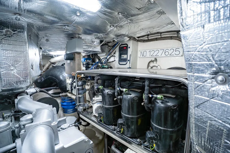 Slide: The Image of Engine room of a 2010 Pershing 80 yacht, showcasing machinery and insulation. - 108