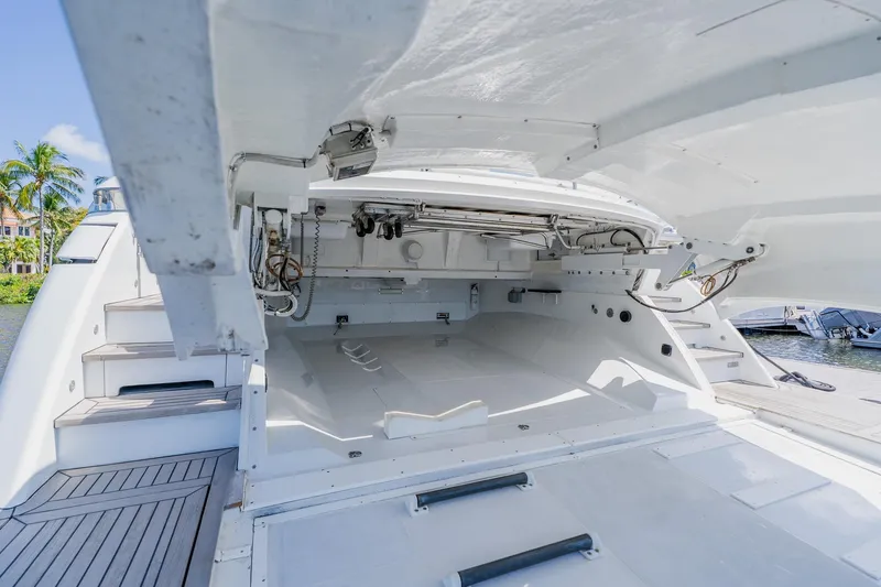 Slide: The Image of Open storage compartment on a 2010 Pershing 80 yacht, docked near palm trees. - 24