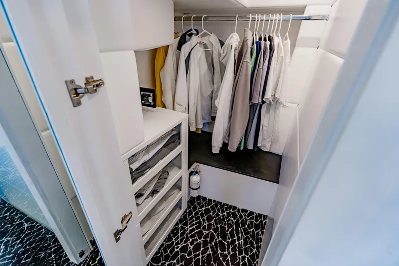 Slide: The Image of Compact closet with hanging clothes and shelves inside a 2010 Pershing 80 yacht. - 35