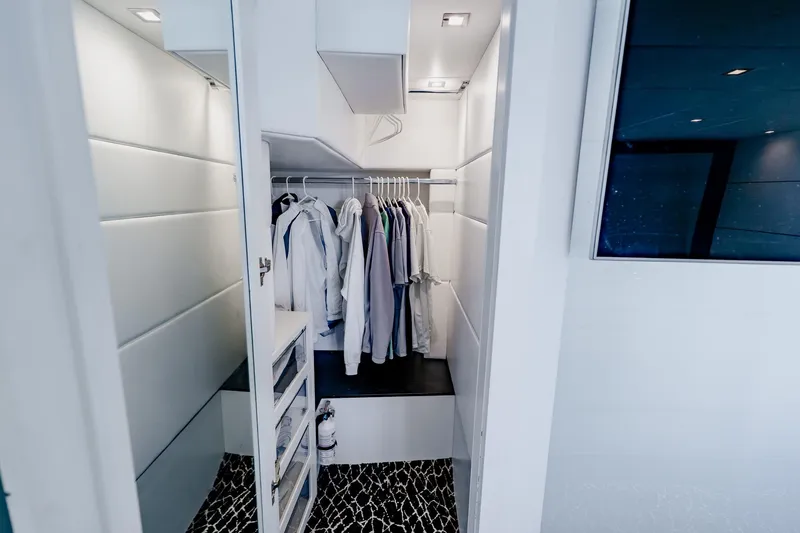Slide: The Image of Modern closet interior on a 2010 Pershing 80 yacht, featuring hanging clothes and sleek design. - 36