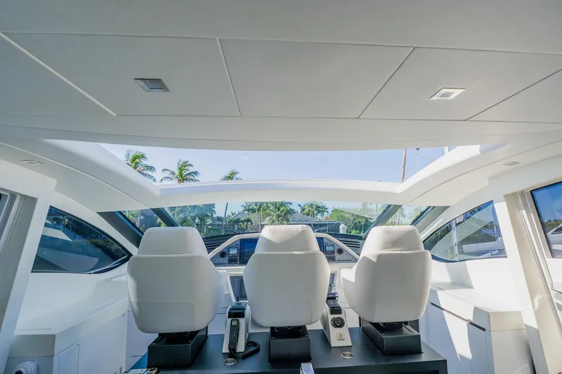 Slide: The Image of Interior view of 2010 Pershing 80 yacht cockpit with three white seats and modern controls. - 76