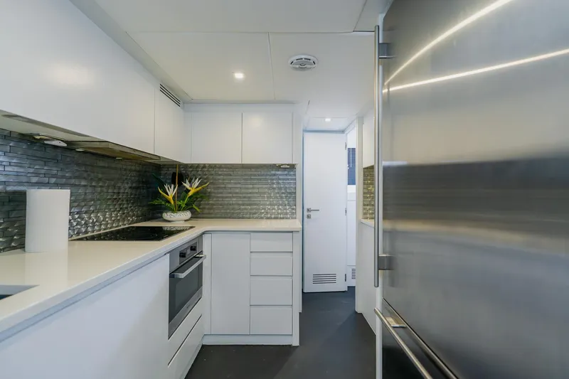 Slide: The Image of Modern kitchen interior on a 2010 Pershing 80 yacht, featuring sleek design and stainless steel appliances. - 82