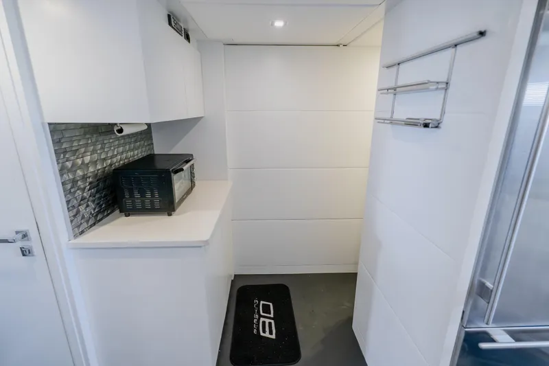 Slide: The Image of Modern galley kitchen in 2010 Pershing 80 yacht with sleek white cabinetry. - 86