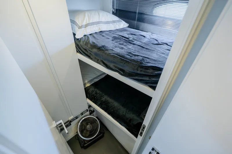 Slide: The Image of Bunk beds in a 2010 Pershing 80 yacht cabin with a small fan below. - 87