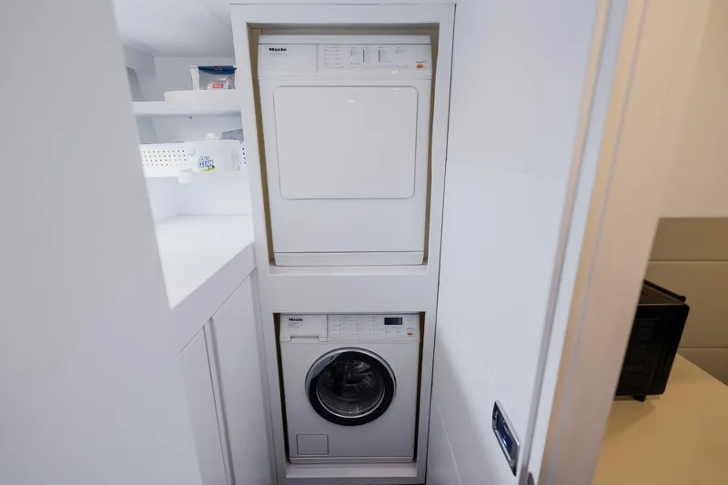 Slide: The Image of Stacked washer and dryer in a modern laundry area on a 2010 Pershing 80 yacht. - 88