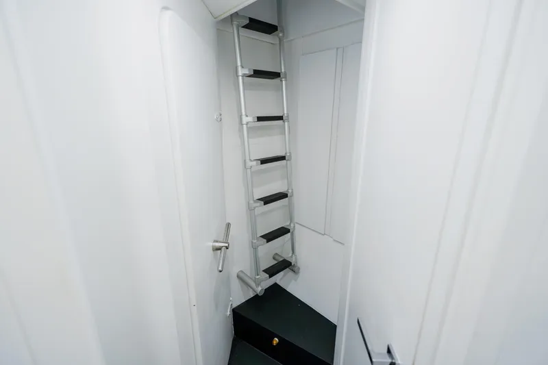 Slide: The Image of Narrow interior ladder in 2010 Pershing 80 yacht, white walls, metal steps. - 90