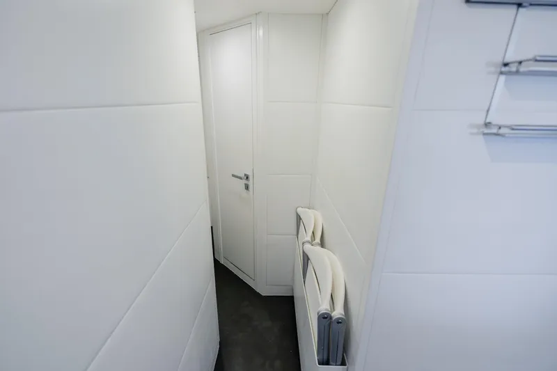 Slide: The Image of Narrow hallway inside 2010 Pershing 80 yacht, featuring sleek white walls and modern design. - 91