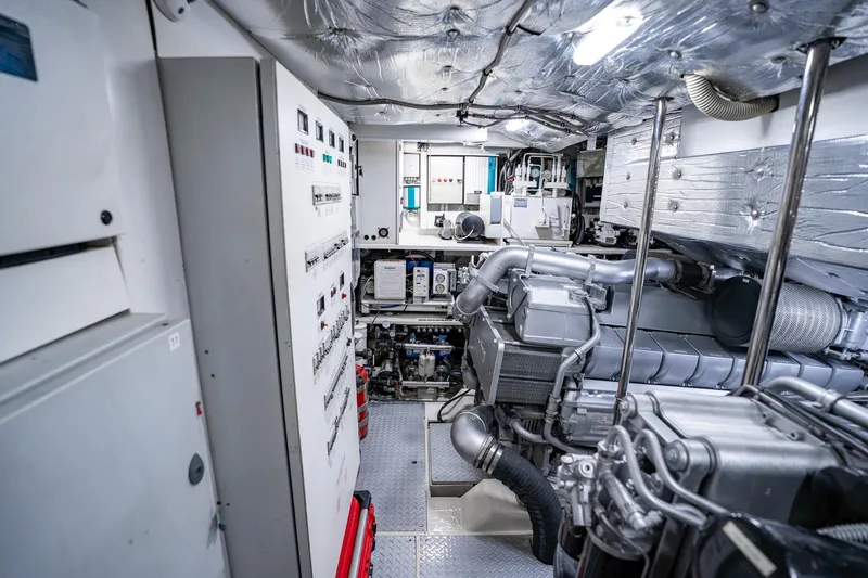 Slide: The Image of Engine room of a 2010 Pershing 80 yacht, showcasing machinery and control panels. - 93
