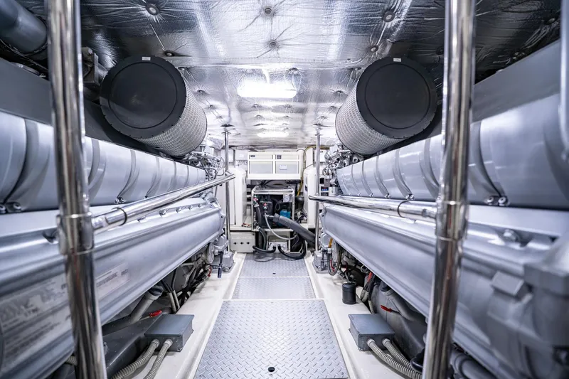 Slide: The Image of Engine room of a 2010 Pershing 80 yacht, featuring dual engines and metallic finishes. - 95