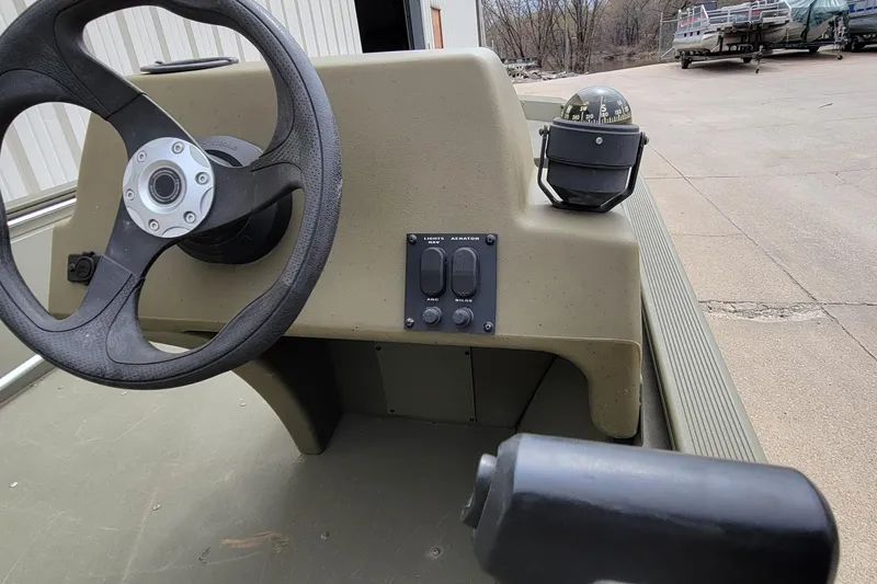 Slide: The Image of 2017 Tracker Grizzly 1648 SC boat console with steering wheel and compass. - 12